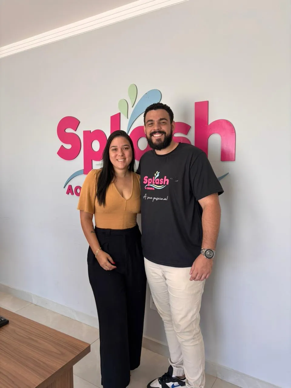 Equipe da Splash, loja de piscinas, em frente ao logo da loja